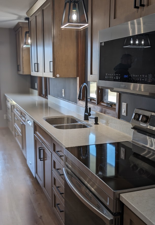 New kitchen remodel with medium brown cabinets, and a new quartz countertop.