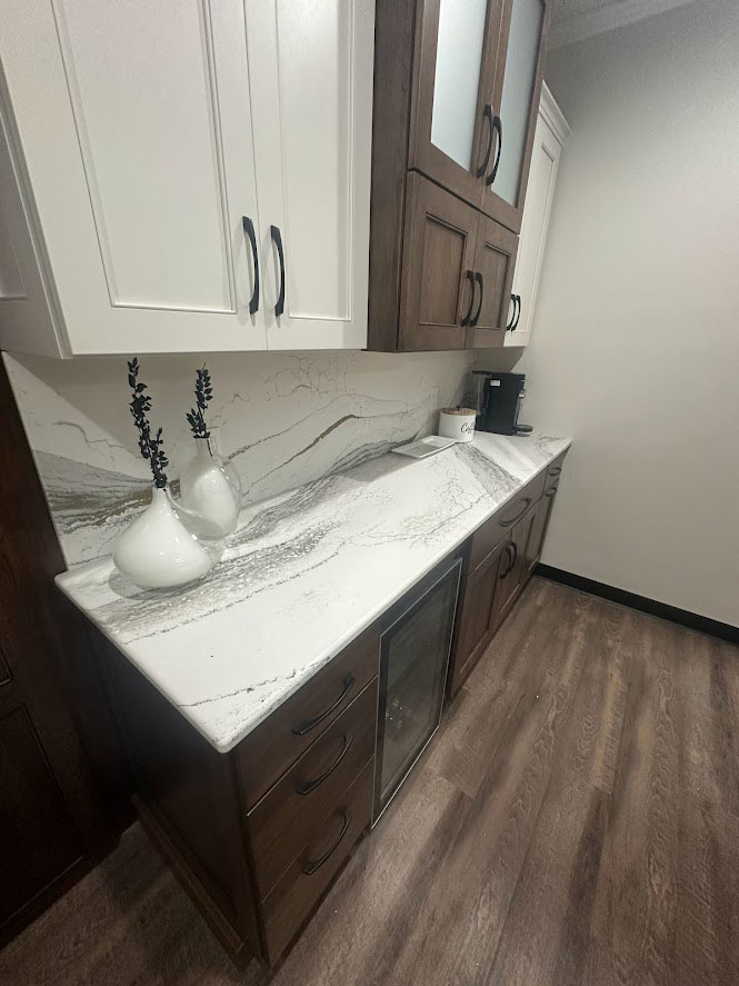 Display of cabinets with a marbled quartz countertop and backsplash