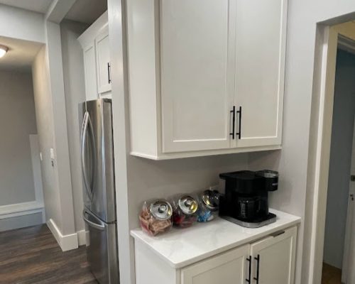 Kitchen remodel showing a a wall with new cabinets and a coffee station.