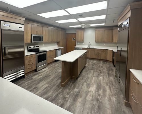 Kitchen remodel showing full view of kitchen through a cutout window space with quartz countertop.