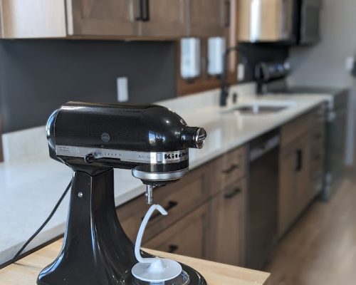 Kitchen remodel showing a closeup of a foldable cutting board with a Kitchenaid stand mixer.