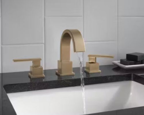 Gold colored bathroom faucet with square design.